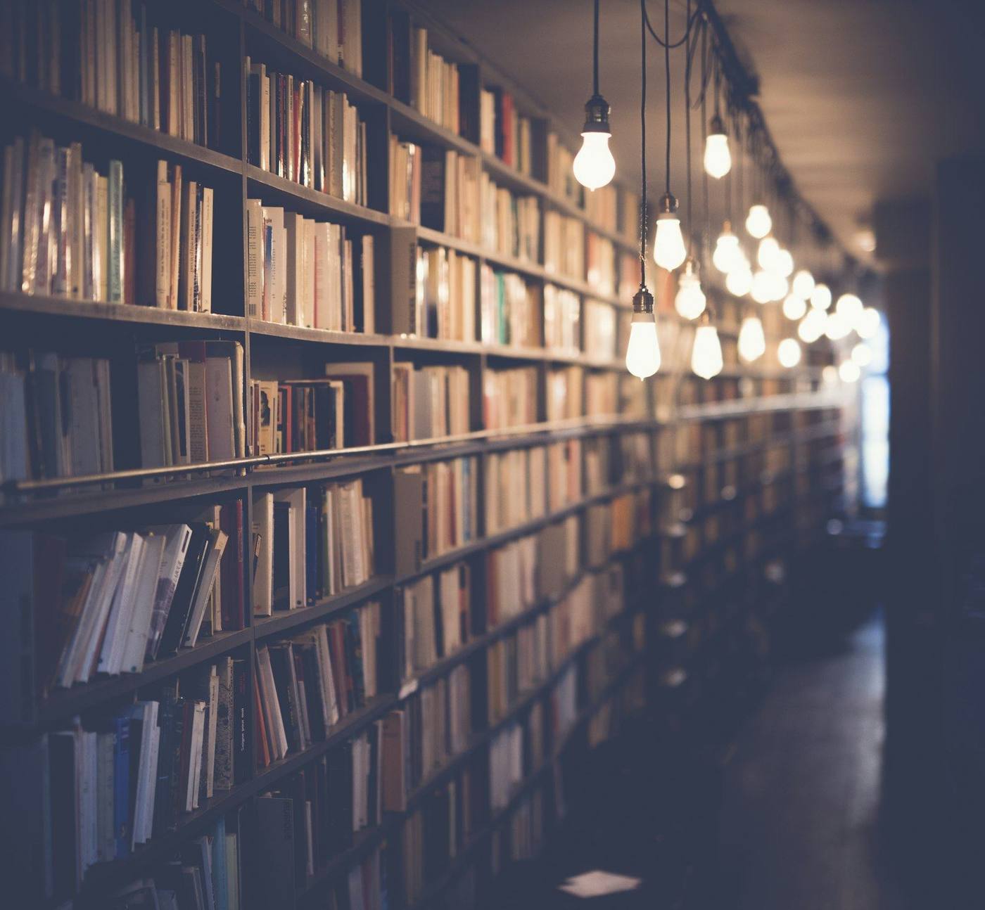 Warm library aisle with hanging lamps